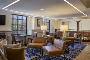A hotel lobby with a seating area, a fireplace, and a staircase. - Phoenix Park Hotel (Washington)
