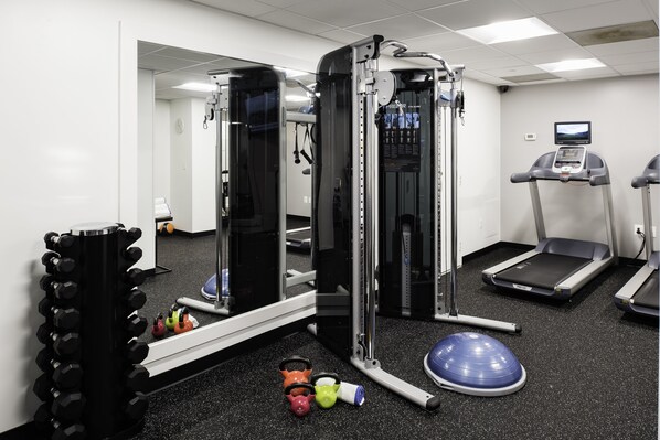 A gym with weight machines, treadmills, and exercise balls.