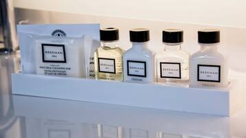 A shelf with four bottles of Beekman 1801 shower gel and a package of Beekman 1801 goat milk cleansing bar.
