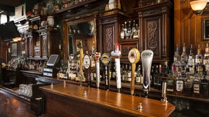 Un bar con múltiples grifos de cerveza y una variedad de botellas de licor.