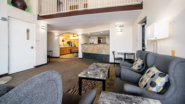 A spacious lobby with a high ceiling, a dining area, and a kitchen in the background. - Quality Inn Near Six Flags St. Louis (Pacific)