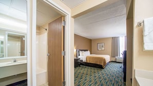 A hotel room with a bathroom, a bed, a nightstand, and a window. - Quality Inn Near Six Flags St. Louis (Pacific)