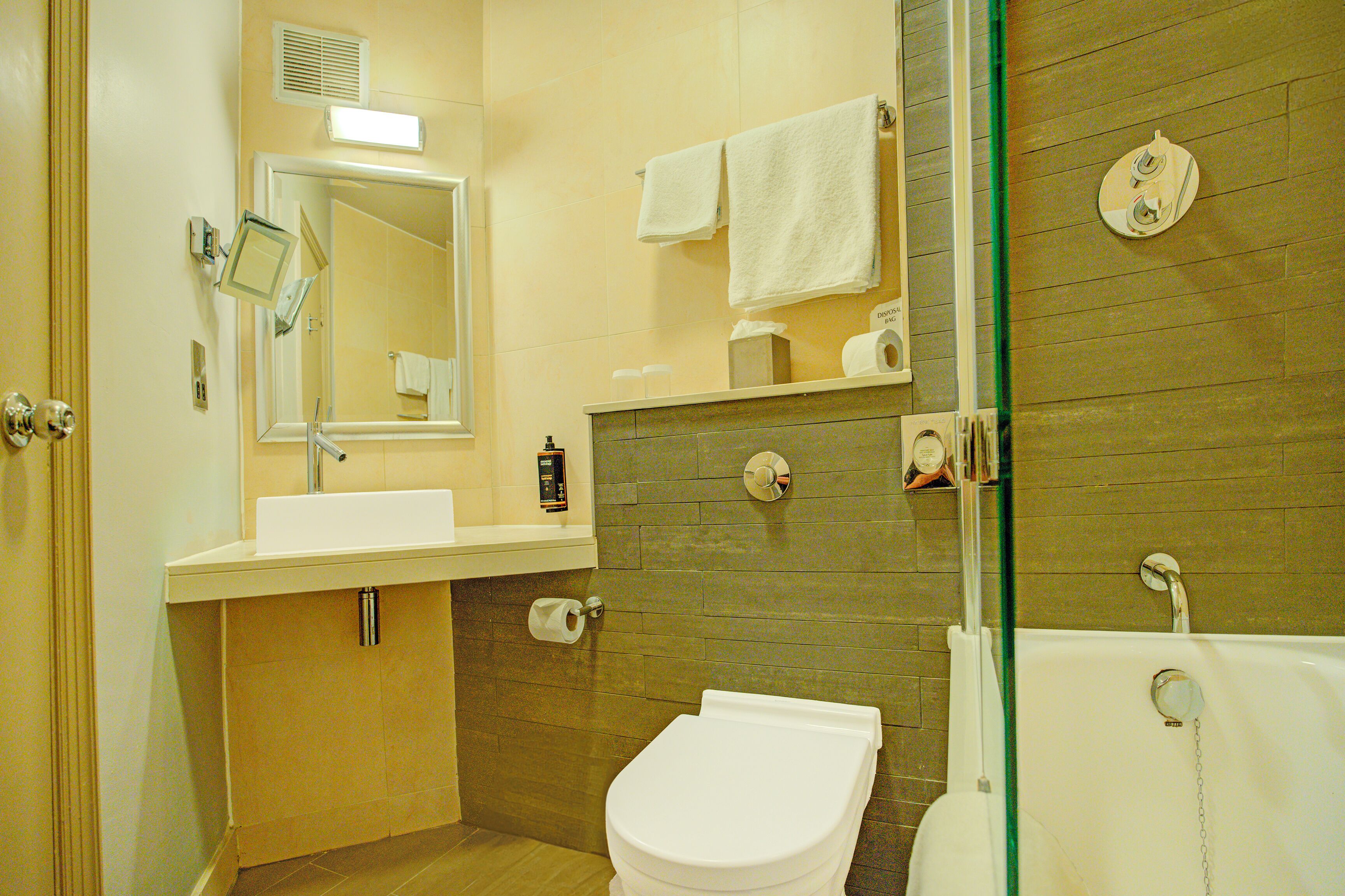 A bathroom with a toilet, sink, and bathtub.