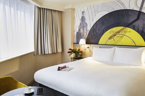 Relax in a stylish room with a comfortable bed, bedside table, and a small table for your essentials.