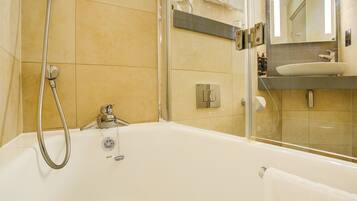 A modern bathroom with a bathtub, shower, and a vanity with a sink.