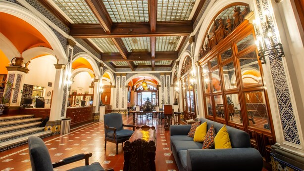 A grand lobby with a high ceiling, ornate columns, and a central seating area with a sofa and armchairs. - Best Western Majestic (Mexico City)