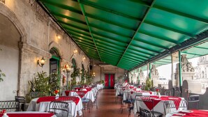 A restaurant with outdoor seating, red and white tablecloths, and a green roof. - Best Western Majestic (Mexico City)