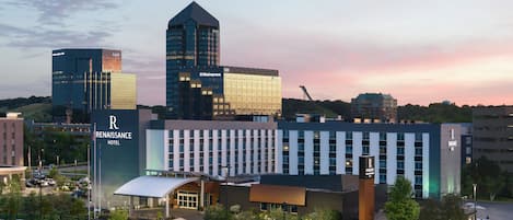A Renaissance Hotel with a modern design, featuring a prominent 'R' logo, a large glass facade, and a well-maintained outdoor area with landscaping.