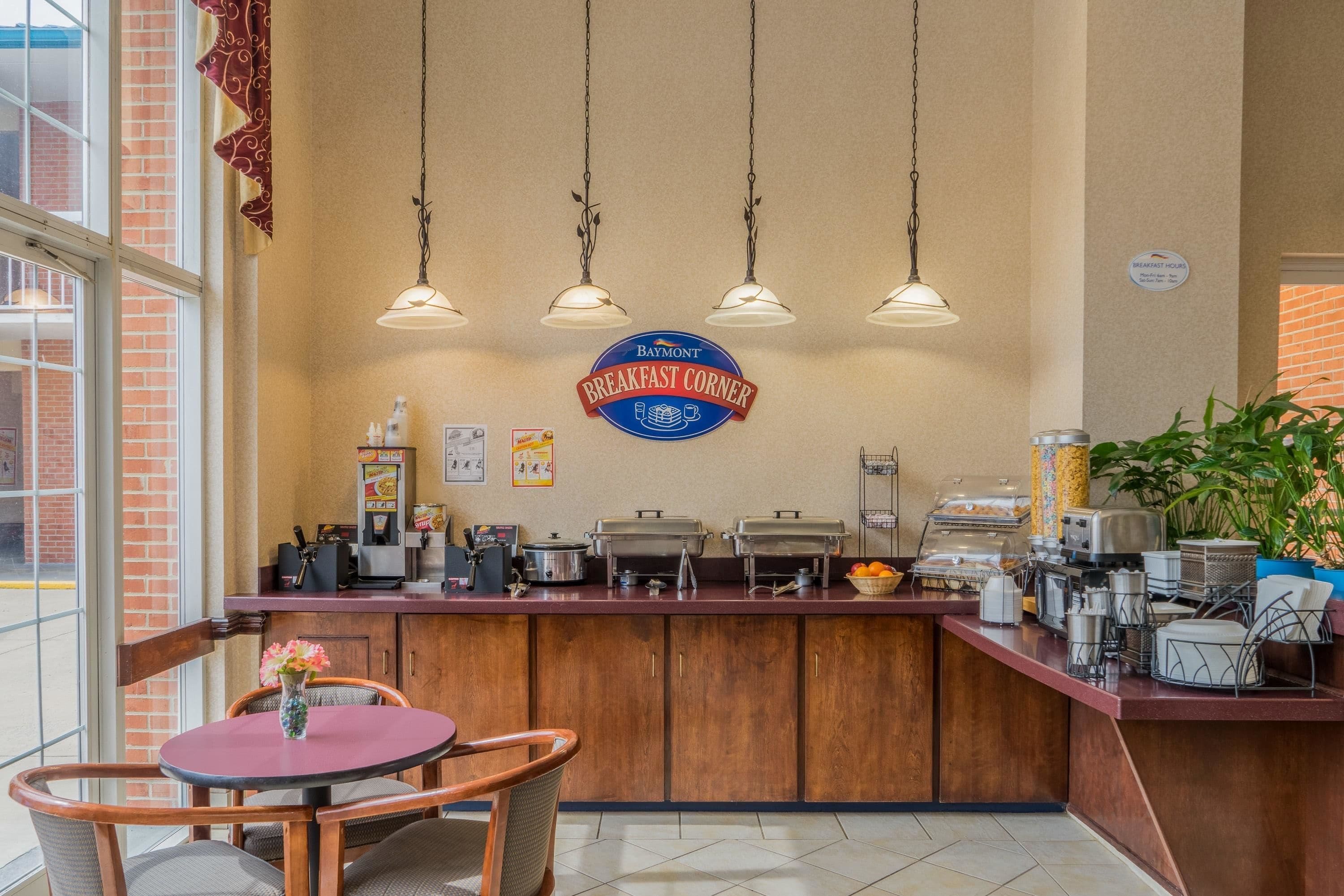 A breakfast area with a counter, buffet, and seating.