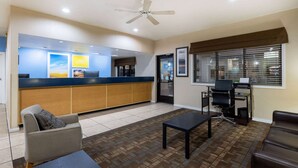 A reception area with a counter, seating, a ceiling fan, and a window with blinds. - Days Inn by Wyndham Roswell (Roswell)