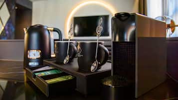 Una estación de café con cafetera, tazas y hervidor.