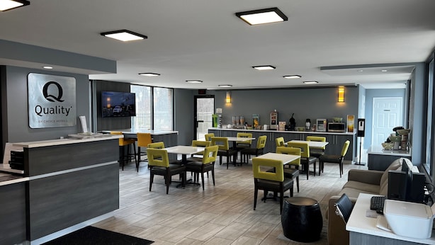 Un moderno vestíbulo de hotel con una recepción, zona de estar y un bar.