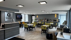 A modern hotel lobby with a reception desk, seating area, and a bar. - Quality Inn Asheville Airport (Fletcher)