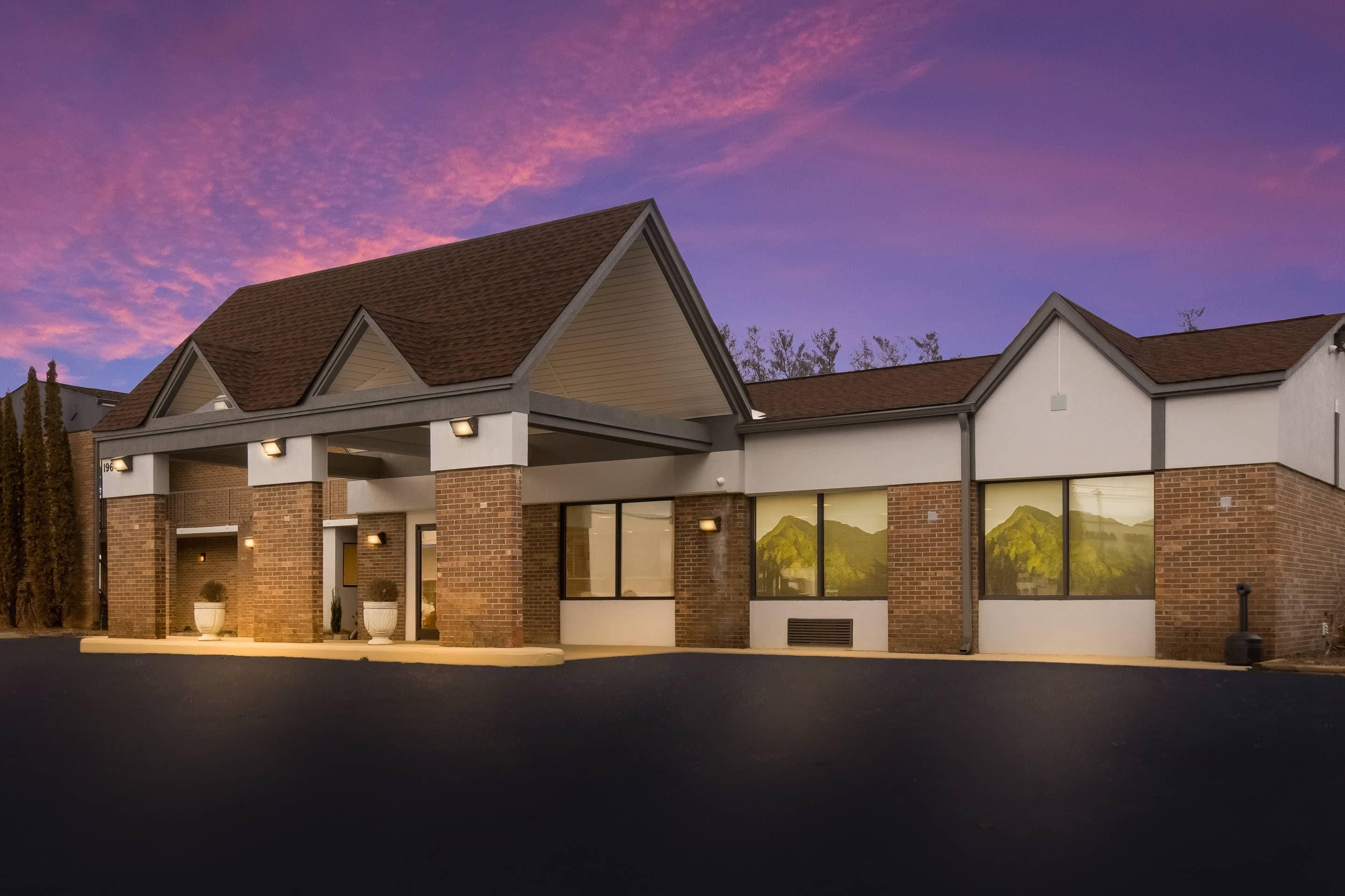 A modern building with a brick facade, large windows, and a covered entrance area.
