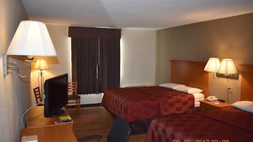 A hotel room with two beds, a desk with a computer, a chair, and lamps.