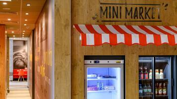 Un petit magasin avec un présentoir réfrigéré et une enseigne au-dessus.