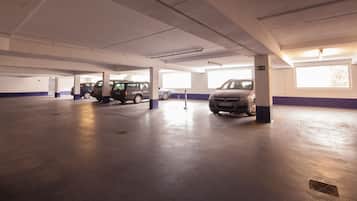 A multi-level parking garage with several cars parked, concrete pillars, and a clean, well-lit environment.