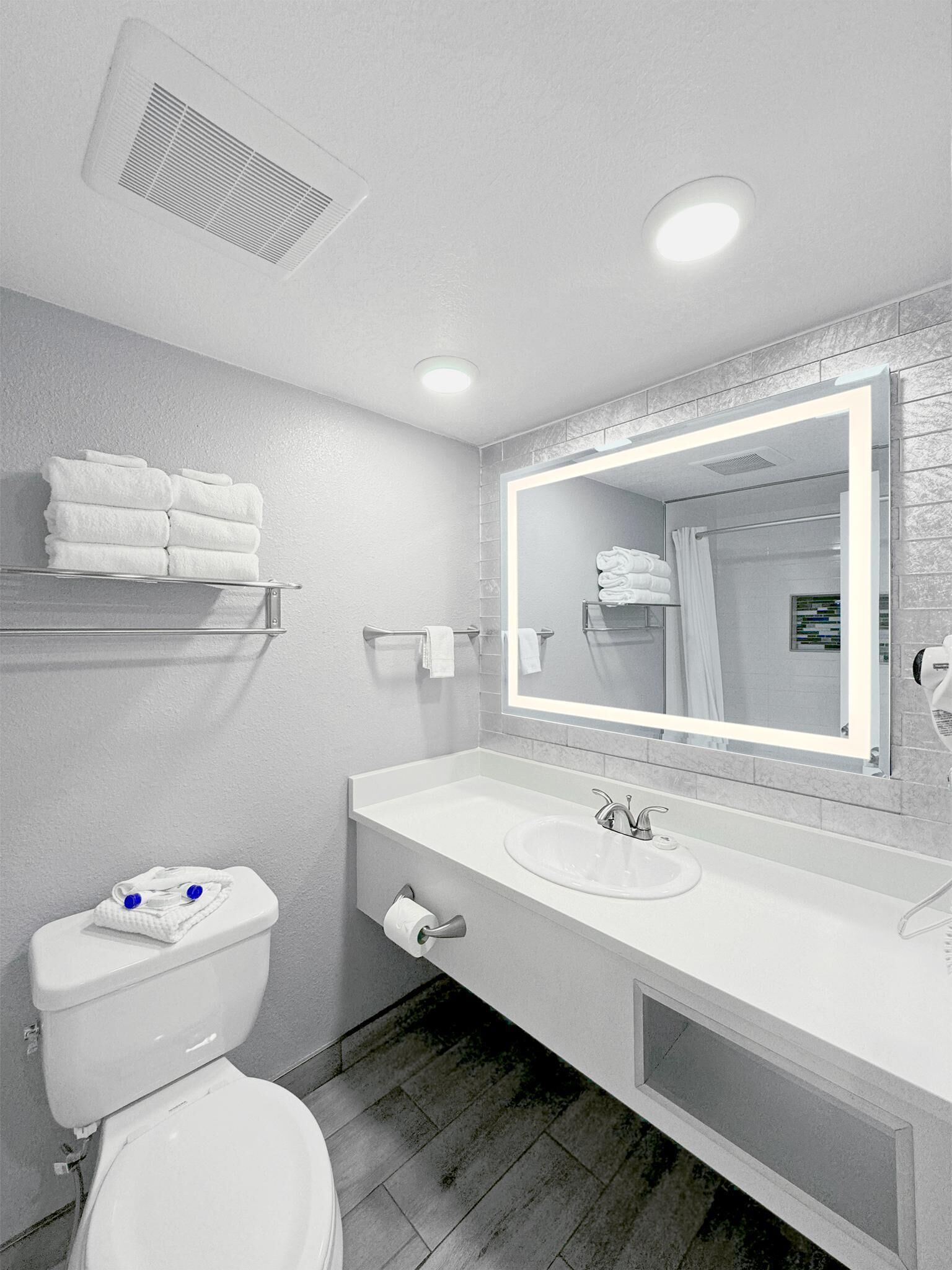 Ein modernes Badezimmer mit Toilette, Waschbecken und Spiegel.