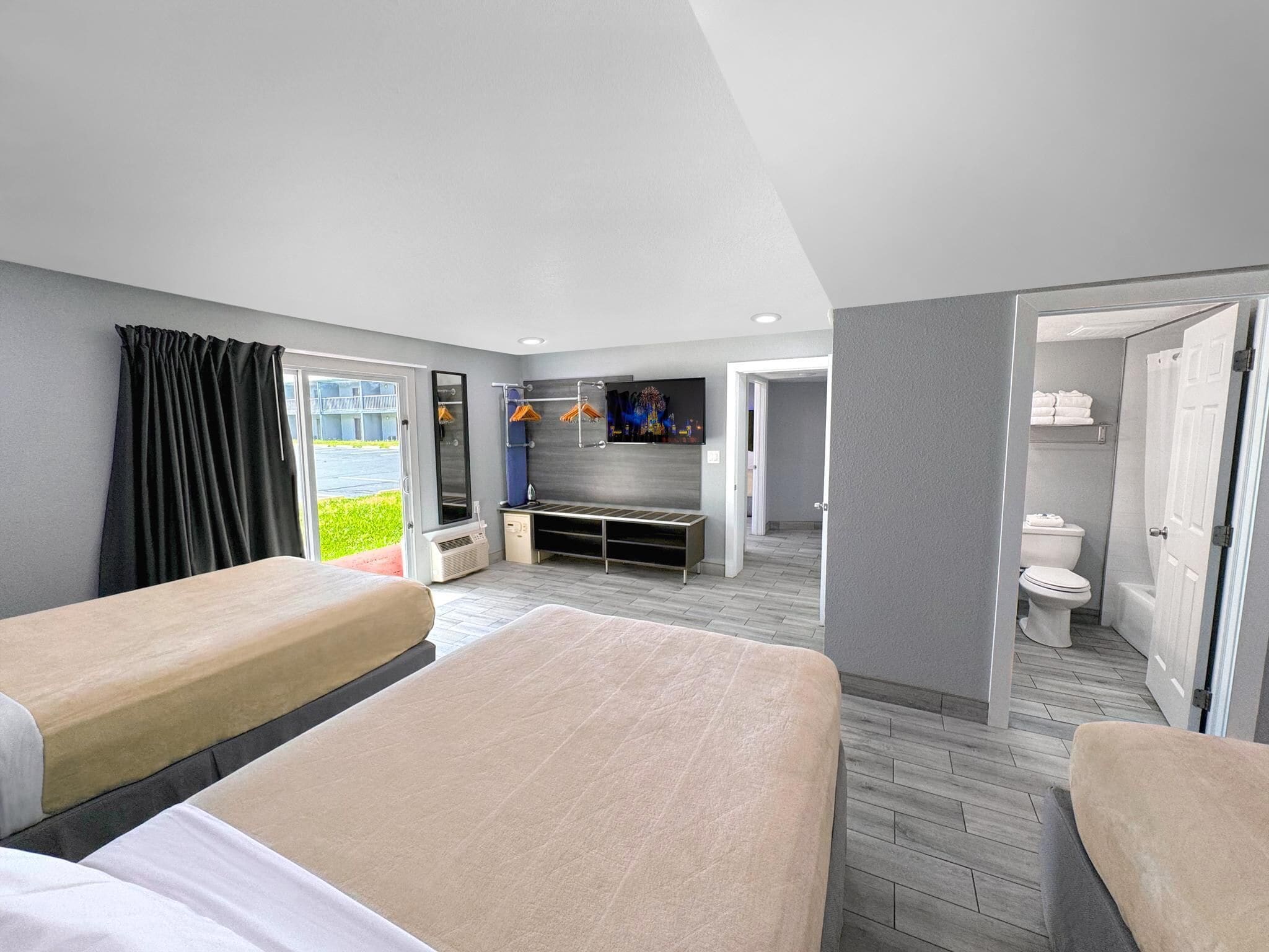 Une chambre d’hôtel avec deux lits, une télévision, une salle de bain et une vue sur l’extérieur.
