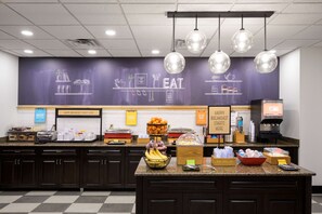 A breakfast bar with a chalkboard menu, a coffee machine, and various food items. - Hampton Inn Evansville/Airport (Evansville)