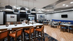 Un comedor moderno con una mesa larga, varias sillas e iluminación colgante.