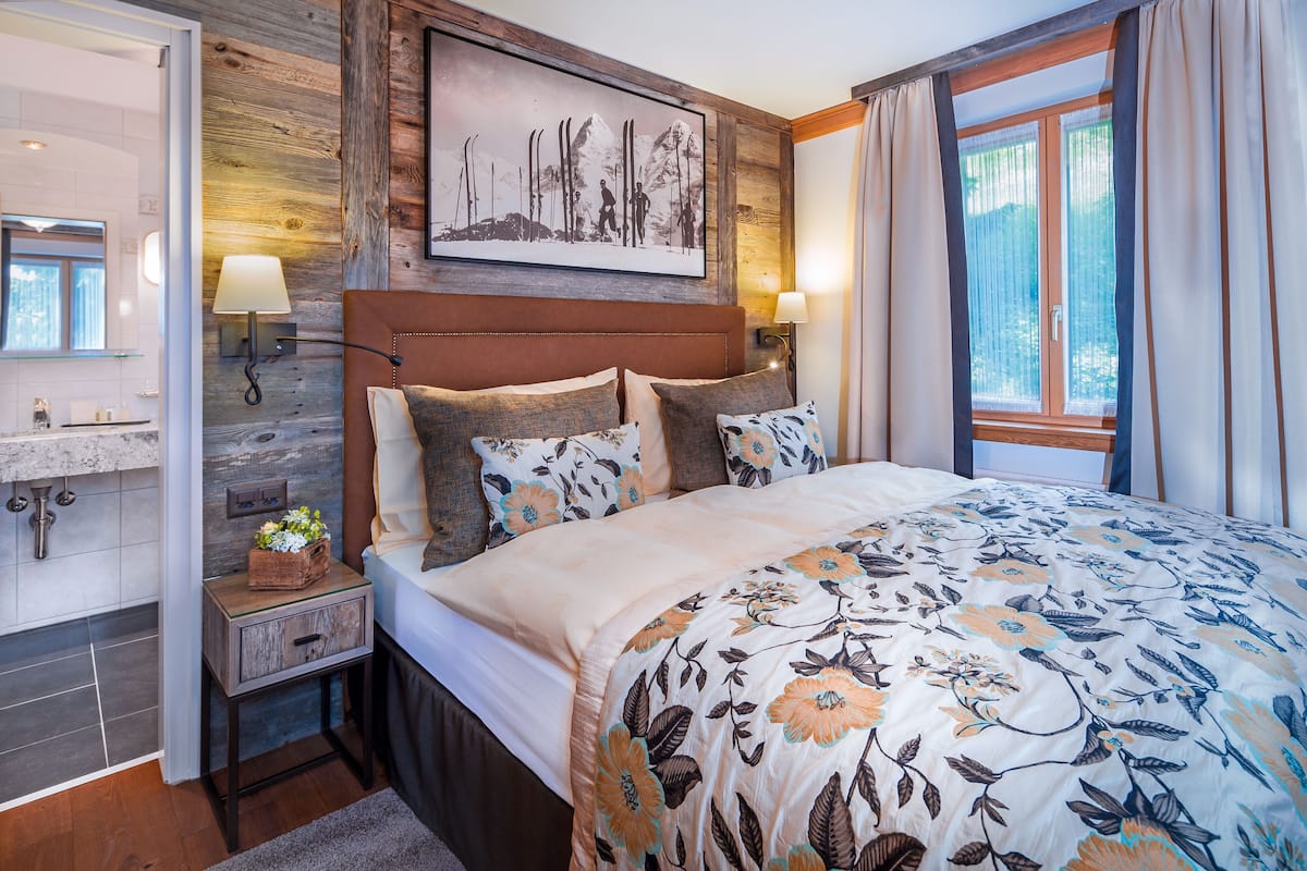 Relax in a stylish room with a large bed, wooden headboard, and a framed photograph above.