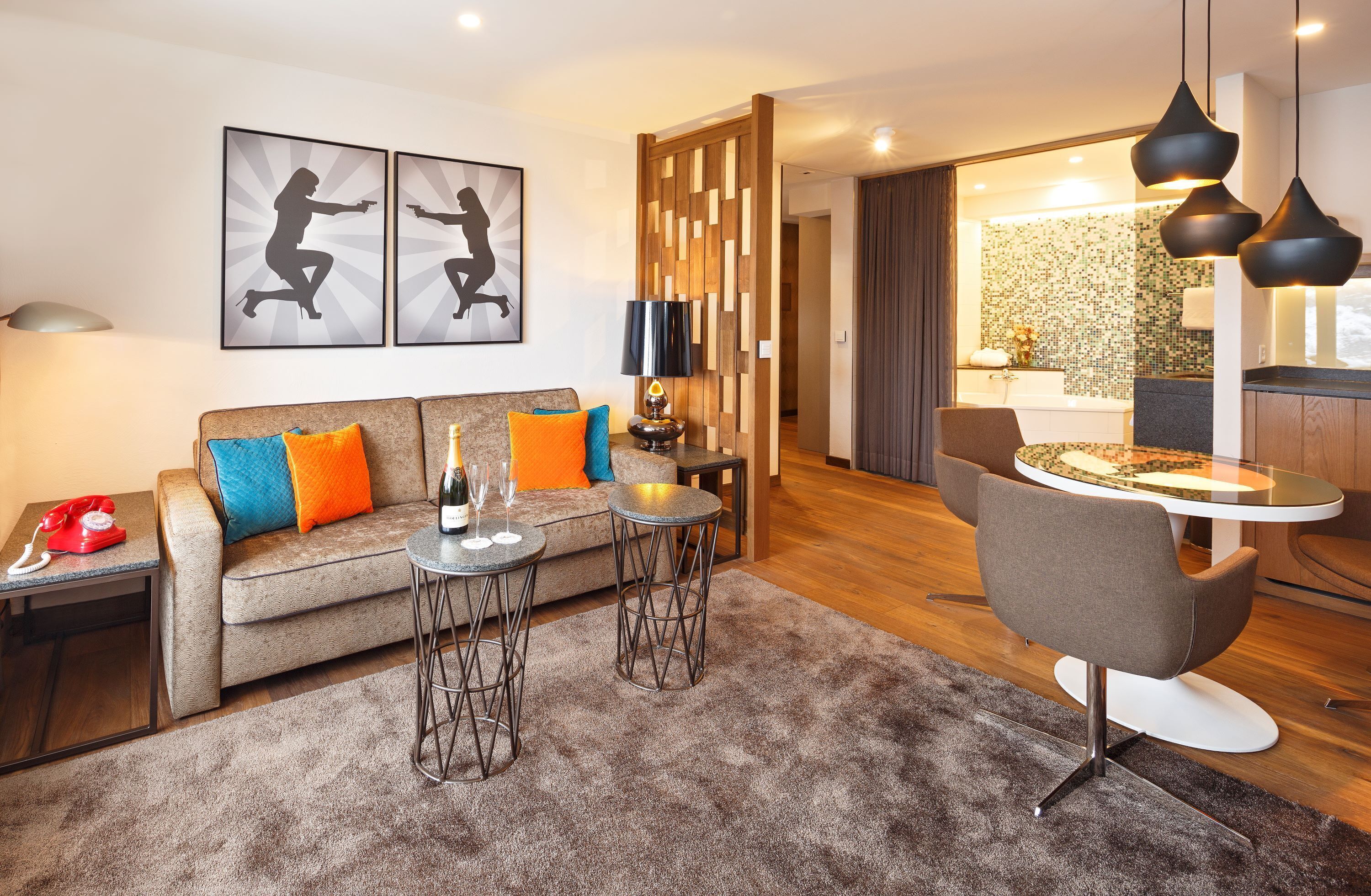 A modern living room with a sofa, two side tables, a coffee table, and a dining area with a chair and table.