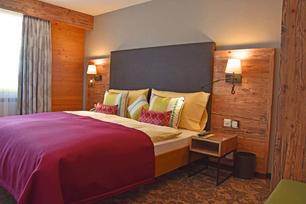 Relax in comfort with a large bed, wooden paneling, and cozy nightstand.