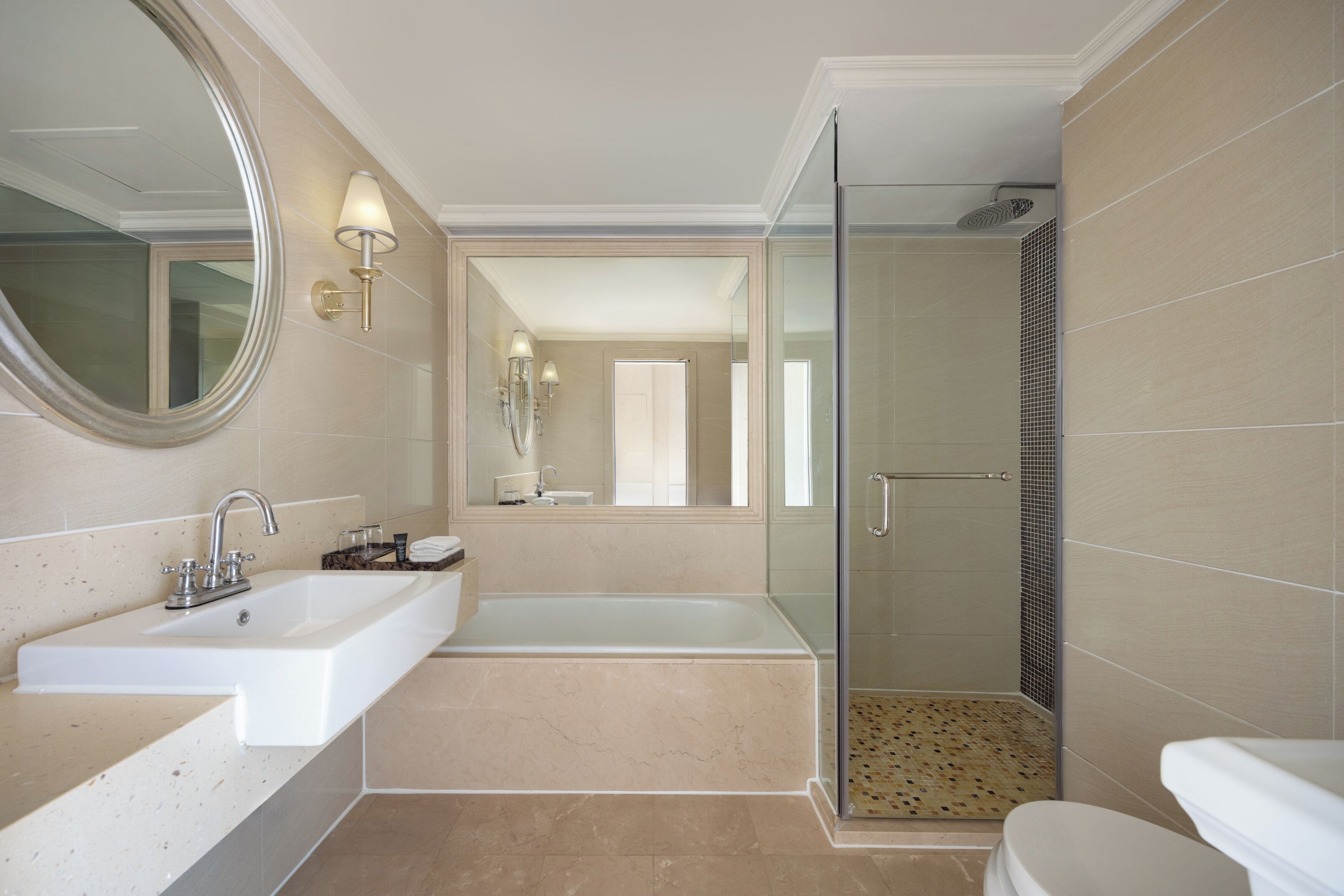 A bathroom with a sink, mirror, bathtub, and shower.