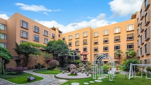 A courtyard with a central fountain, surrounded by well-maintained grass and stone pathways. - Sheraton Guilin Hotel (Guilin)
