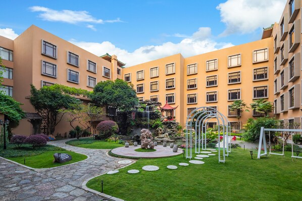 A courtyard with a central fountain, surrounded by well-maintained grass and stone pathways. - Sheraton Guilin Hotel (Guilin)