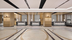 A modern hotel lobby with a reception desk, seating area, and a large marble floor. - Sheraton Guilin Hotel (Guilin)