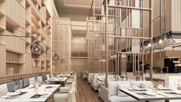 A modern restaurant with long tables, cushioned seating, and a wooden interior. - Sheraton Guilin Hotel (Guilin)