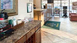 A hotel lobby with a coffee station, a reception desk, and a view of the street outside. - Quality Inn San Angelo (San Angelo)