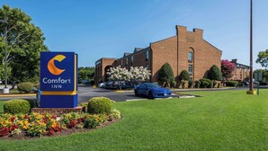 Een Comfort Inn hotel met een gebouw van baksteen, een parkeerplaats en een naambord.