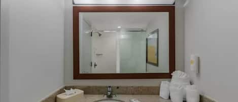 A bathroom with a sink, mirror, and toiletries.
