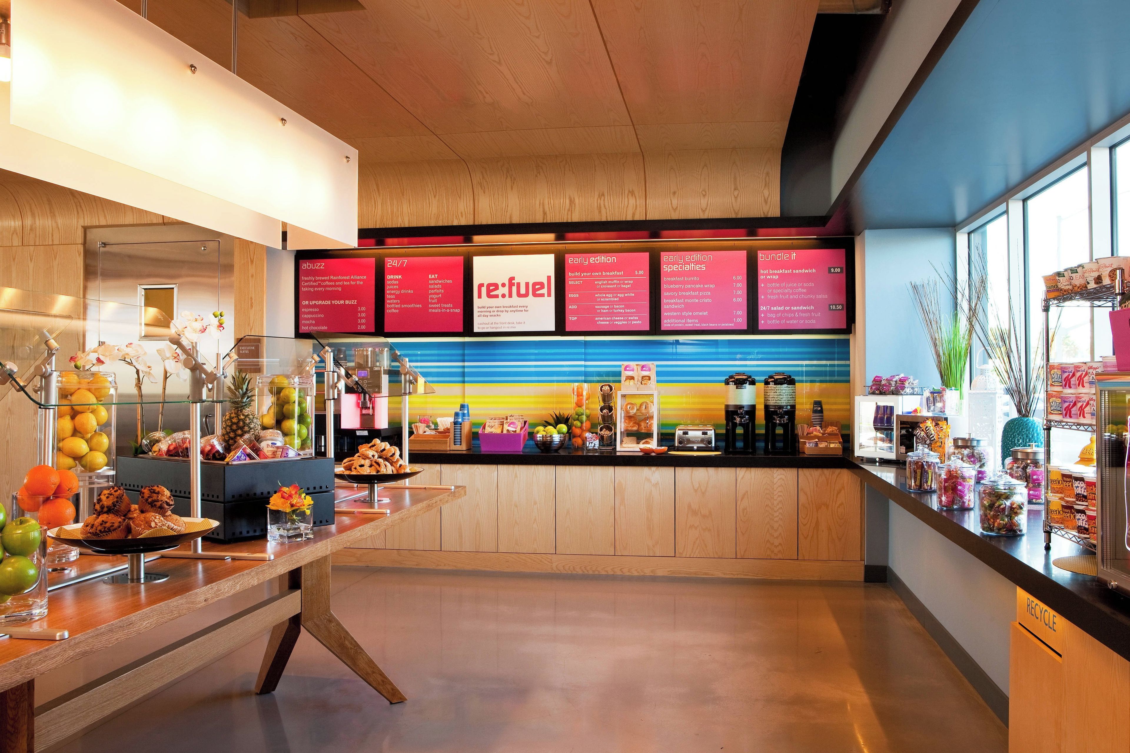 A breakfast bar with a variety of food items and a menu board displaying breakfast options.
