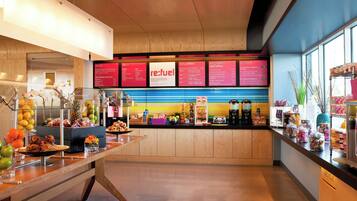 A breakfast bar with a variety of food items and a menu board displaying breakfast options.