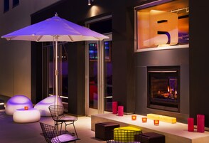 A modern outdoor seating area with a fire feature, illuminated by ambient lighting.