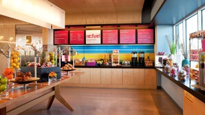 A breakfast buffet area with various food items and a menu board. - Aloft by Marriott Tucson University (Tucson)