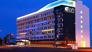A modern hotel with multiple floors, a prominent 'aloft' sign, and a well-lit entrance area. - Aloft by Marriott Tucson University (Tucson)