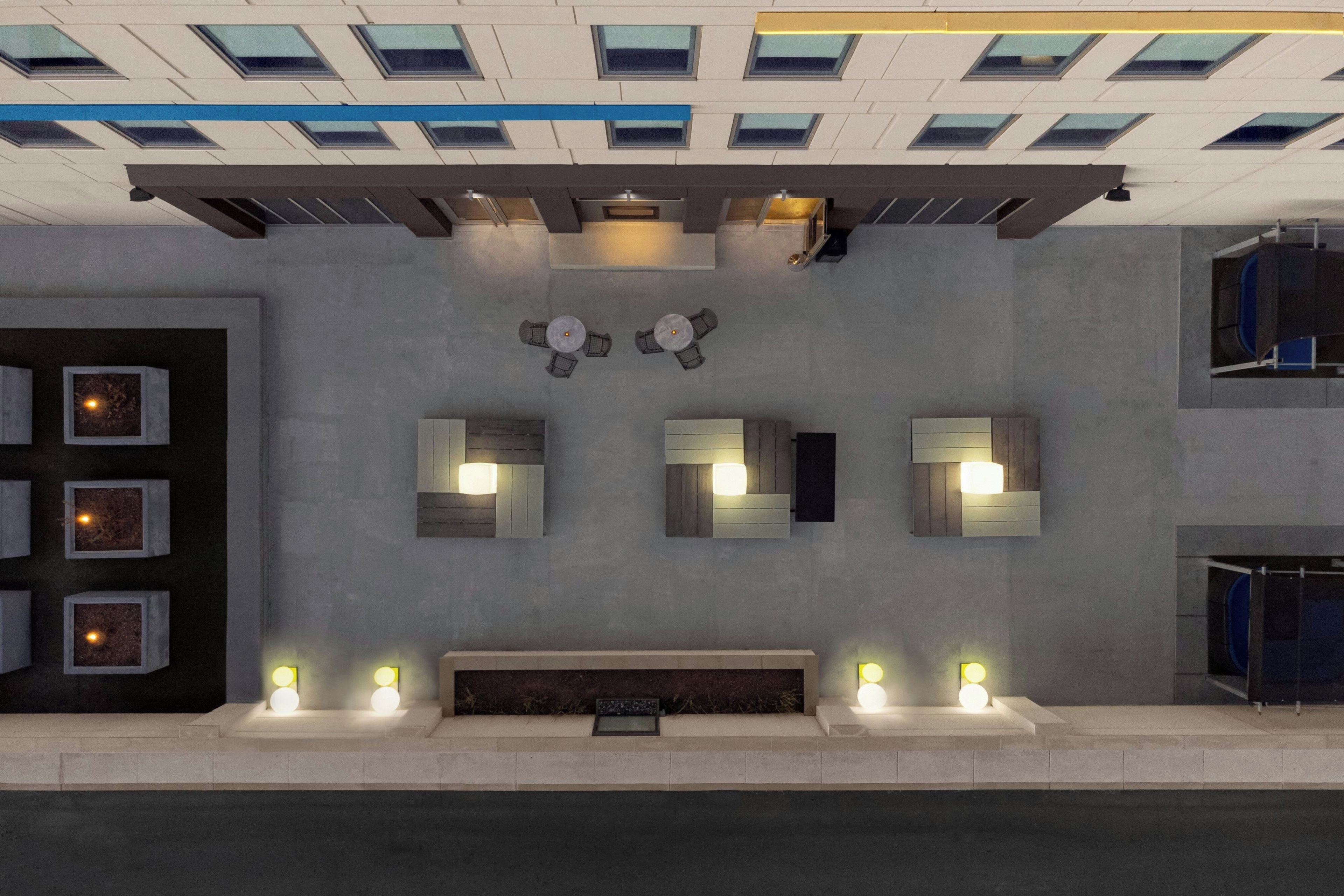 Een modern interieur met een centraal zitgedeelte, inbouwverlichting en een gedessineerd plafond.