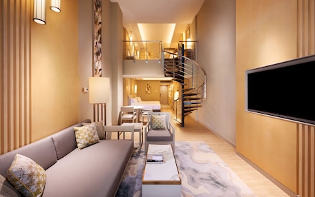 A modern living room with a sofa, coffee table, and a flat-screen TV.