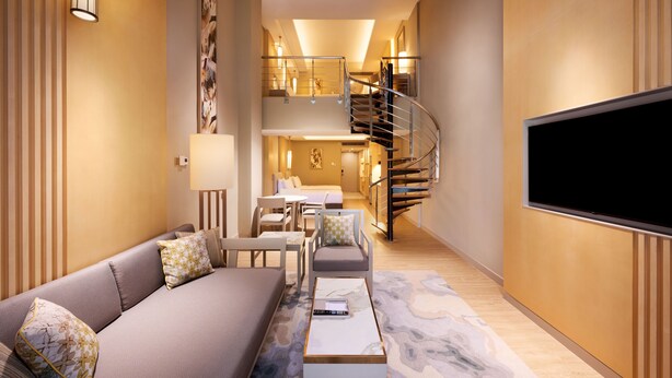 A modern living room with a sofa, coffee table, and a flat-screen TV.