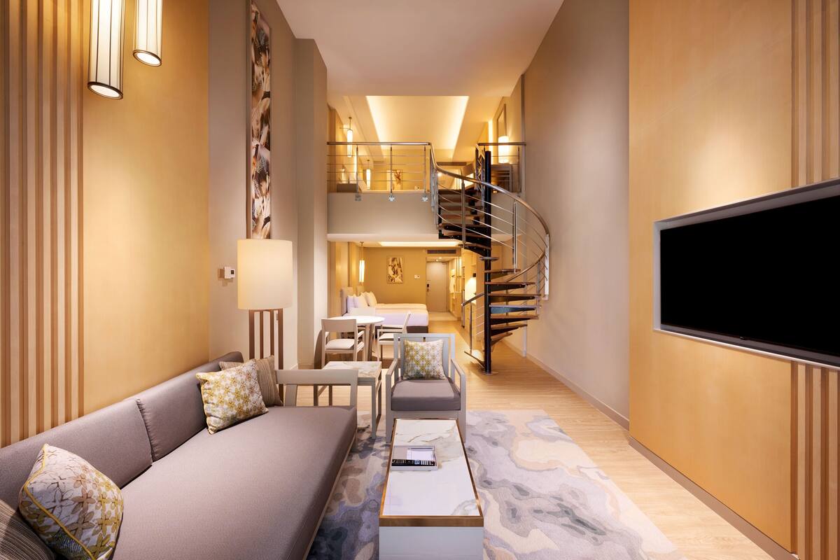 Un salon moderne avec un canapé, une table basse et un téléviseur à écran plat.