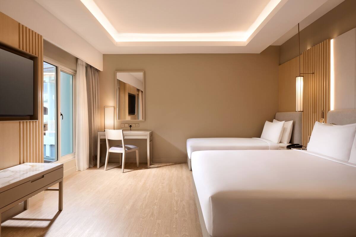 Une chambre d’hôtel équipée d’un lit, d’un bureau, d’une chaise et d’un téléviseur.