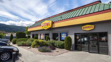Situated in a landscaped area, Denny's offers a welcoming entrance with a glass door.