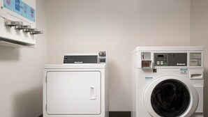 A laundry area with two white washing machines, one with a control panel and the other with a front-loading door. - Holiday Inn Express Andover North-Lawrence by IHG (Lawrence)