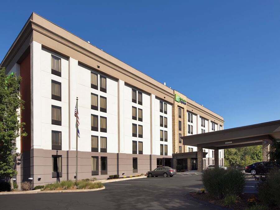 A multi-story hotel with a flat facade, a covered entrance, and a parking lot.
