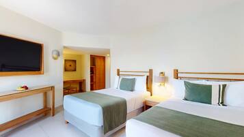 A hotel room with two beds, a desk, and a TV.